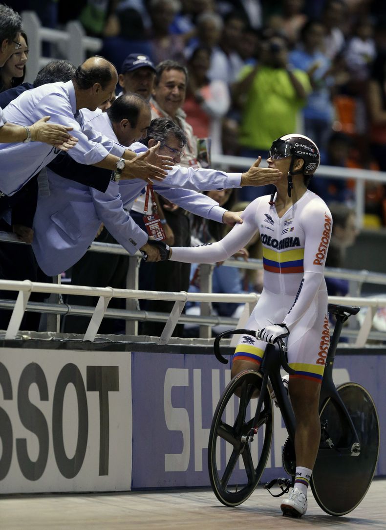El colombiano Fabian Parra recibe las felicitaciones de sus compatriotas tras ganar la medalla de plata en la prueba de keirin varonil en el Mundial de Ciclismo de Pista que se celebra en Cali, Colombia, el jueves 27 de febrero de 2014. (Foto de AP/Fernan