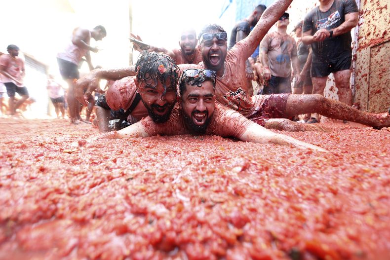 Personas disfrutan de la tradicional Tomatina, la guerra anual de tomates en Buñol, España, el 30 de agosto de 2023. (Foto AP/Alberto Saiz)