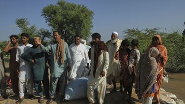 Aldeanos miran a un bote de rescate que llega para evacuarlos de una zona inundada en Muhammad Pur Ghotta, en el distrito de Multan, Pakistán, el jueves 11 de septiembre de 2025. (AP Foto/Asim Tanveer)