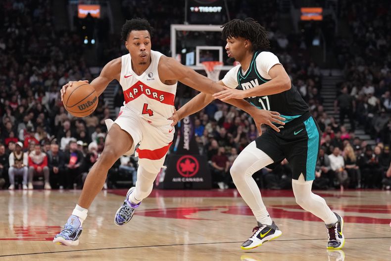 Scottie Barnes, de los Raptors de Toronto, avanza frente a Shaedon Sharpe, de los Trail Blazers de Portland, en el duelo del martes 2 de diciembre de 2025 (Nathan Denette/The Canadian Press via AP)
