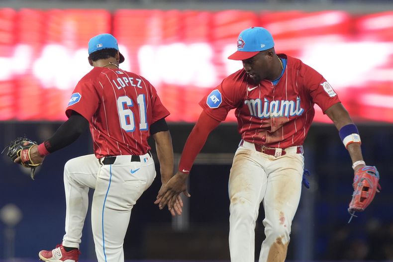 El segunda base de los Marlins de Miami, Otto López (61), y el jardinero derecho Jesús Sánchez celebran después de derrotar a los Filis de Filadelfia 9-5 el sábado 7 de septiembre de 2024, en Miami. (AP Foto/Marta Lavandier)