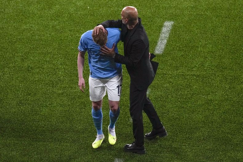 El entrenador del Manchester City Pep Guardiola consuela a Kevin De Bruyne luego de salir lesionado del campo durante la final de la Liga de Campeones ante el Inter de Milán, el sábado 10 de junio de 2023, en Estambul. (AP Foto/Thanassis Stavrakis)