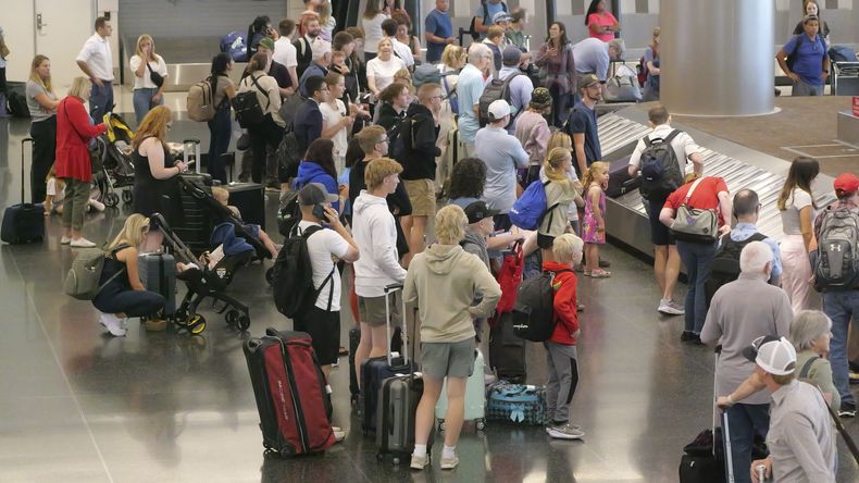 Vacacionistas esperan su equipaje tras arribar al Aeropuerto Internacional de Salt Lake City, el miércoles 3 de julio de 2024, en Salt Lake City. (AP Foto/Rick Bowmer)