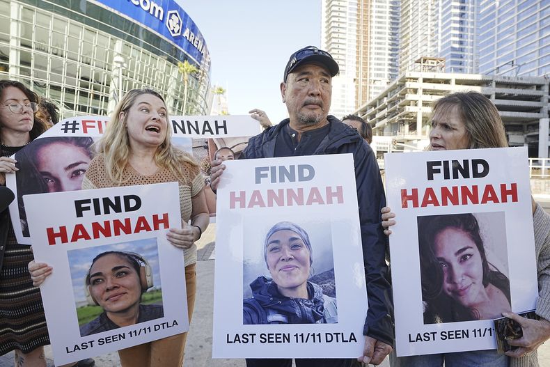 Ryan Kobayashi, en el centro, sostiene una foto de su hija desaparecida Hannah Kobayashi fuera Crypto.com Arena, jueves, 21 de noviembre 2024 en Los Ángeles. (AP foto/Damian Dovarganes)