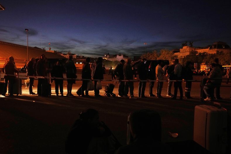 Un grupo de personas se reúne fuera de la estación de trenes de Atocha durante un gran apagón en Madrid, el lunes 28 de abril de 2025. (AP Foto/Manu Fernandez)