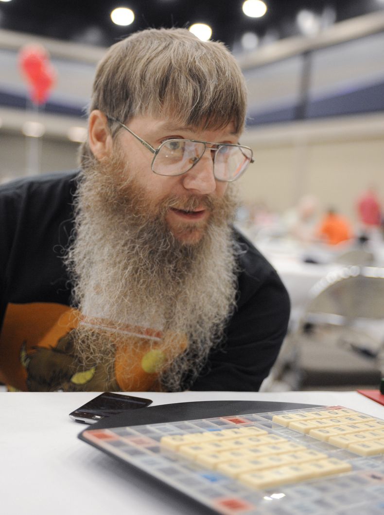 ARCHIVO - El favorito del torneo y pentacampeón del mundo de Scrabble en inglés Nigel Richards mira al otro lado del tablero antes de su ronda final el miércoles 13 de agosto de 2014 en el Campeonato Nacional de Scrabble en Buffalo, Nueva York. (AP Foto/Gary Wiepert, Archivo)