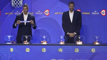 El embajador de FIBA y exestrella de la NBA Luis Scola muestra el papel con el nombre de España junto al exbasketbolsita alemán Dirk Nowitzki durante el sorteo al Mundial de Baloncesto en Quezon, Filipinas el sábado 29 de abril del 2023. (AP Foto/Josefino de Guzman)