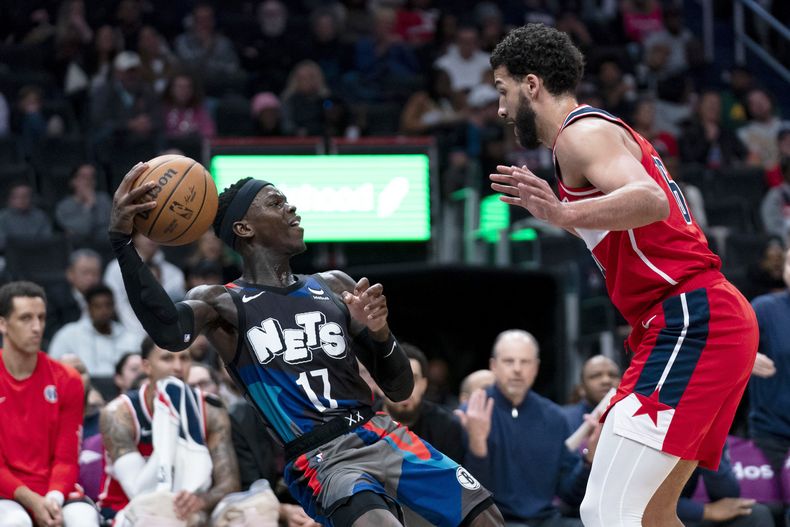 Dennis Schroder, base alemán de los Nets de Brooklyn, controla el balón frente a Anthony Gill, de los Wizards de Washington, en el partido del miércoles 27 de marzo de 2024 (AP Foto/Stephanie Scarbrough)