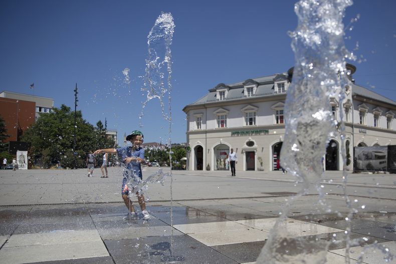 Un niño juega en una fuente bajo el intenso calor en Pristina, la capital de Kosovo, el jueves 3 de julio de 2025. (AP Foto/Visar Kryeziu)