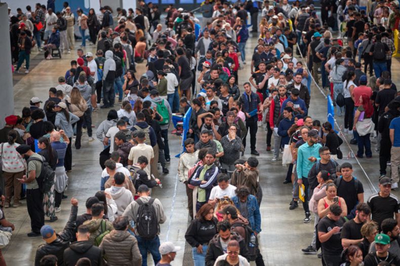 ARCHIVO - Migrantes hacen fila en una oficina institucional para obtener documentación de cara a regularizar su residencia en España, en LHospitalet de Llobregat cerca de Barcelona, España, el 21 de abril de 2026. (AP Foto/Emilio Morenatti, Archivo)