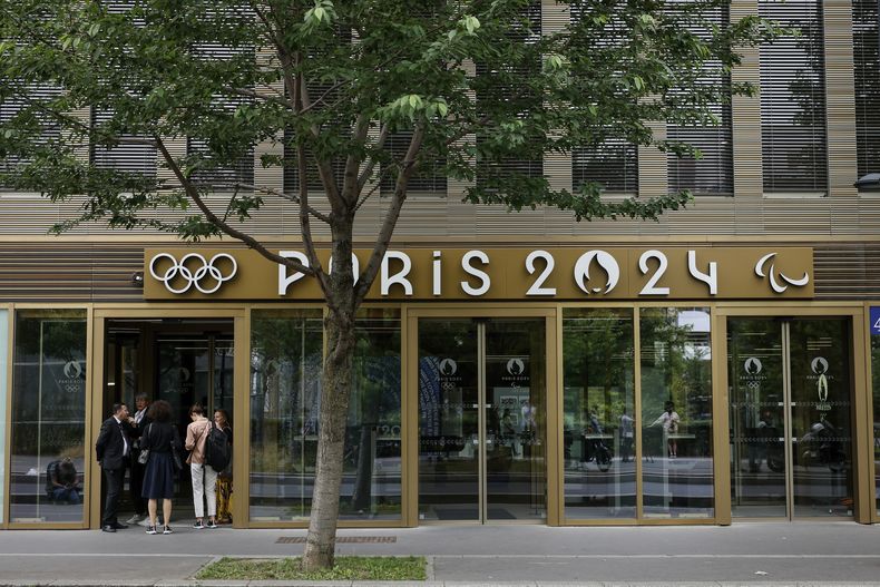 ARCHIVO - Un grupo de personas afuera de la sede del comité organizador de los Juegos Olímpicos de París, el martes 20 de junio de 2023, en el suburbio de Saint-Denis. (AP Foto/Thomas Padilla)