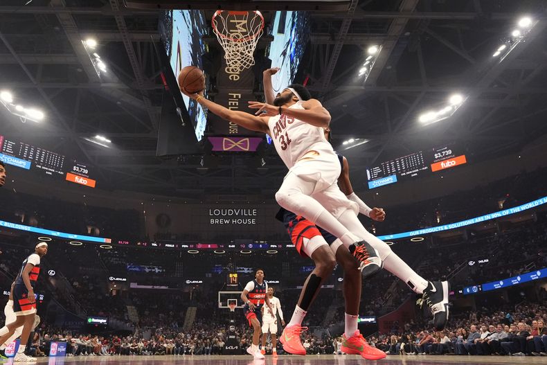 Jarrett Allen (31), de los Cavaliers de Cleveland, dispara frente a Alexandre Sarr, de los Wizards de Washington, durante la primera mitad del juego de baloncesto de la NBA, el viernes 13 de diciembre de 2024, en Cleveland. (AP Foto/Sue Ogrocki)