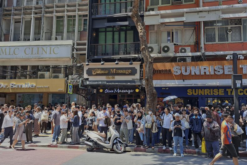 Una multitud aguarda en la calle tras evacuar edificios luego de un terremoto, el viernes 28 de marzo de 2025, en Bangkok, Tailandia. (AP Foto/Chutima Lalit)