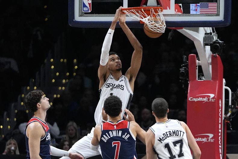 Victor Wembanyama, pívot francés de los Spurs de San Antonio, realiza una clavada ante los Wizards de Washington, el sábado 20 de enero de 2024 (AP Foto/Mark Schiefelbein)