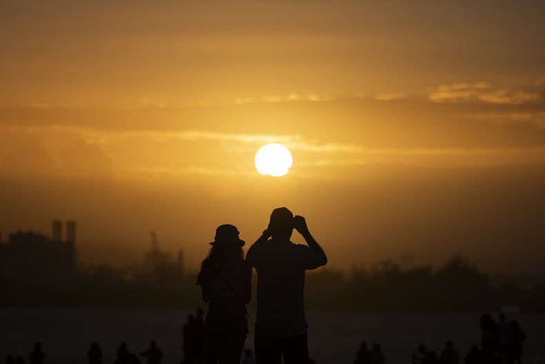 Dos personas observan el atardecer en El Morro durante los festejos de la Calle San Sebastián, el 21 de enero de 2024, en San Juan, Puerto Rico. (AP Foto/Alejandro Granadillo, Archivo)