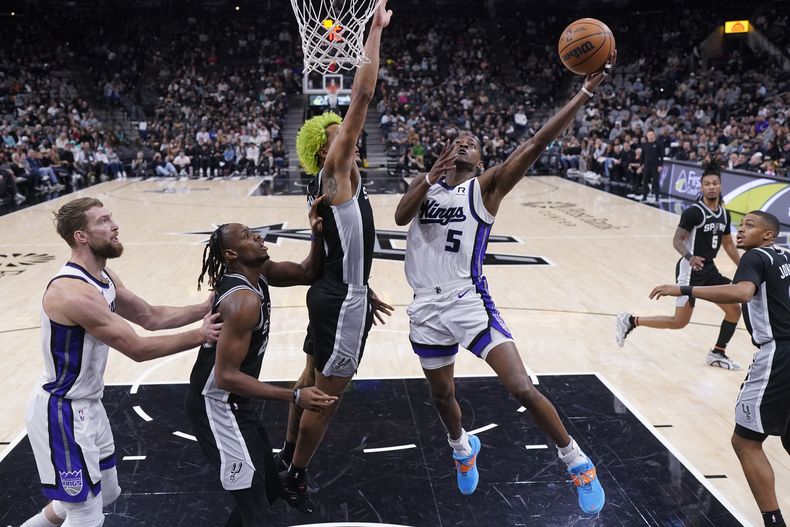 DeAaron Fox (5), de los Kings de Sacramento, ataca la canasta mientas Jeremy Sochan, centro, de los Spurs de San Antonio, durante la primera mitad del juego de baloncesto de la NBA, el viernes 6 de diciembre de 2024, en San Antonio. (AP Foto/Eric Gay)