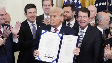 El presidente estadounidense Donald Trump muestra la Ley GENIUS, que regula las stablecoins, un tipo de criptomoneda, tras firmarla en la Sala Este de la Casa Blanca, el viernes 18 de julio de 2025, en Washington. (AP Foto/Alex Brandon)