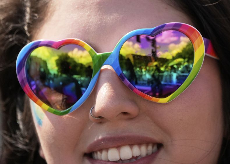 Una persona con gafas en forma de corazón y con los colores del arcoíris mira el desfile del Orgullo Mundial LGBTQ+ el sábado 7 de junio de 2025, en Washington. (AP Foto/Alex Brandon)
