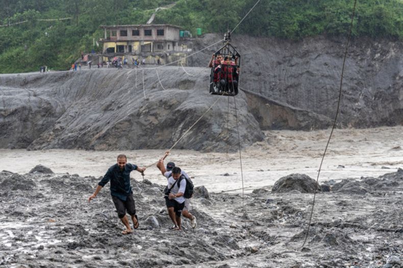 Residentes utilizan una tirolesa recién instalada para ayudar a la gente a cruzar el río Trishuli tras las inundaciones repentinas, el 2 de septiembre de 2026, en Bidur, en el distrito de Nuwakot, Nepal. (AP Foto/Rajesh Kumar Singh)