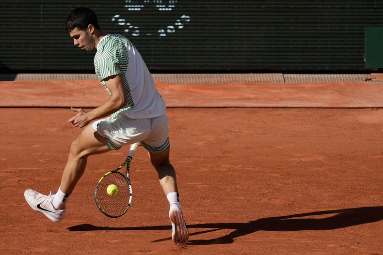 Carlos Alcaraz devuelve por debajo de las piernas ante Lorenzo Musetti durante el partido de los cuartos de final del Abierto de Francia, el domingo 4 de junio de 2023. (AP Foto/Thibault Camus)