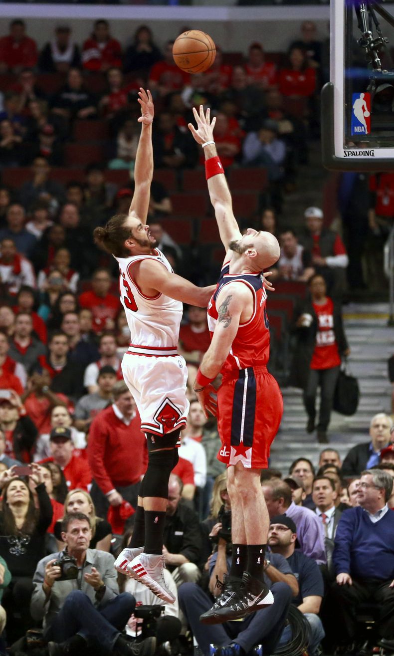 El centro de los Bulls de Chicago, Joakim Noah, izquierda, lanza sobre la marca del centro de los Wizards de Washington, Marcin Gortat, durante la primera mitad del quinto juego de la serie de playoffs el martes 29 de abril de 2014 en Chicago. (AP Photo/C