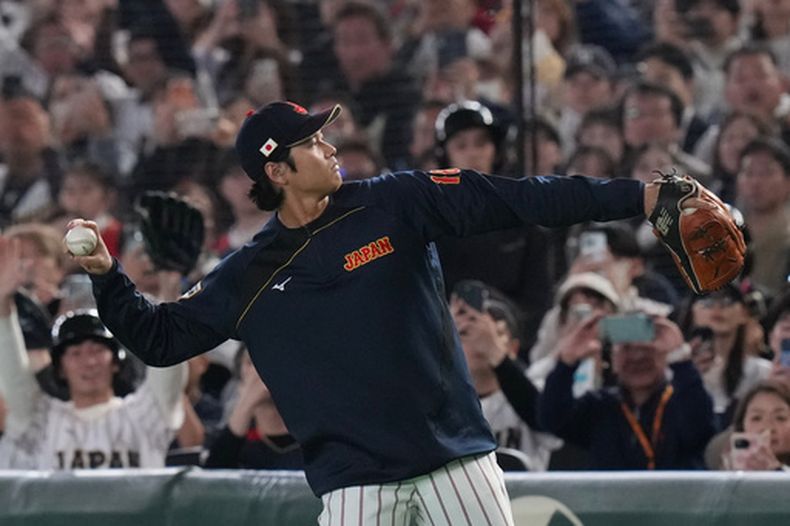 El astro japonés Shohei Ohtani suelta el brazo previo al sexto inning del juego contra la República Checa en el Clásico Mundial, el martes 10 de marzo de 2026, en Tokio. (AP Foto/Eugene Hoshiko)