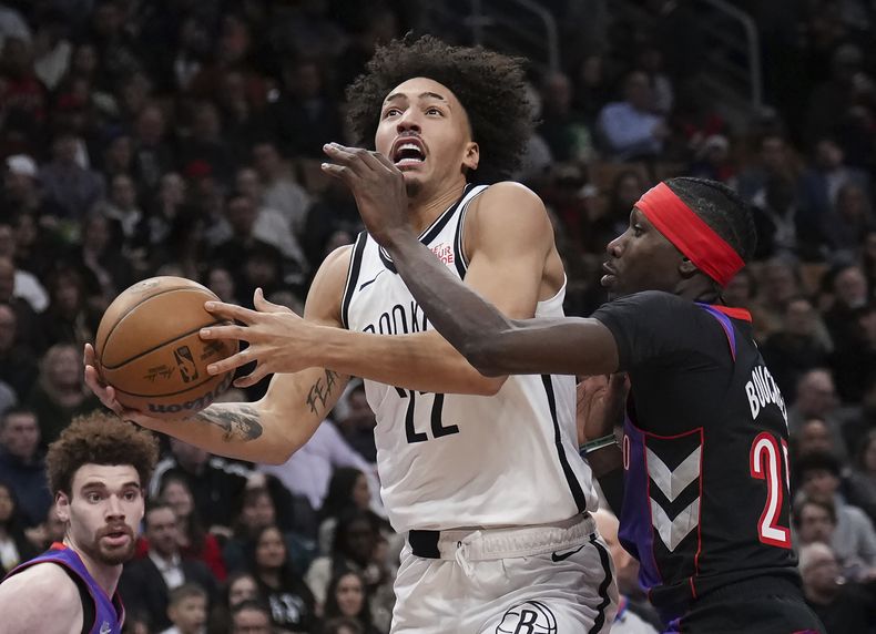 El alero de los Nets de Brooklyn Jalen Wilson avanza con el balón hacia la canasta frente al alero de los Raptors de Toroto Chris Boucher en el encuentro del jueves 19 de diciembre del 2024. (Nathan Denette/The Canadian Press via AP)