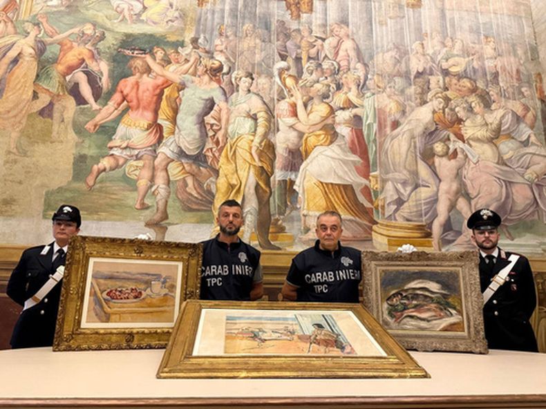 En esta fotografía proporcionada por los Carabineros italianos, agentes posan junto a tres cuadros recuperados tras una operación policial, en Parma, en el norte de Italia, el viernes 14 de agosto de 2026. (Carabineros italianos vía AP)