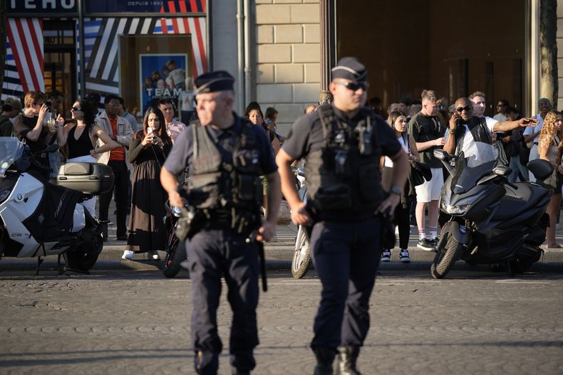 Agentes de policía vigilan la zona de la avenida de los Campos Elíseos donde se produjo un apuñalamiento, el jueves 18 de julio 2024, en París. (Foto AP/David Goldman)
