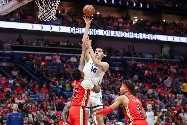 Zach Edey (14), de los Grizzlies de Memphis, dispara a una mano a la canasta sobre Derik Queen (2) de los Pelicans de Nueva Orleans, en la segunda mitad del juego de baloncesto de la Copa NBA, el miércoles 26 de noviembre de 2025, en Nueva Orleans. (AP Foto/Peter Forest)