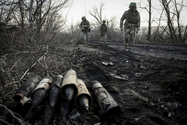 Militares ucranianos recogen munición dañada en la carretera en el frente cerca de Chasiv Yar, en la región de Donetsk, Ucrania, el viernes 10 de enero de 2025. (Oleg Petrasiuk/24ta brigada mecanizada de Ucrania via AP)