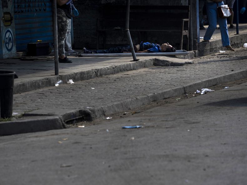 El cadáver del taxista Juan Carlos Barrezueta yace a las puertas de la tienda de recambios de autos donde se paró con su vehículo para realizar una compra, en Durán, una ciudad ubicada frente a Guayaquil, Ecuador, el 29 de septiembre de 2023. (AP Foto/Rodrigo Abd)