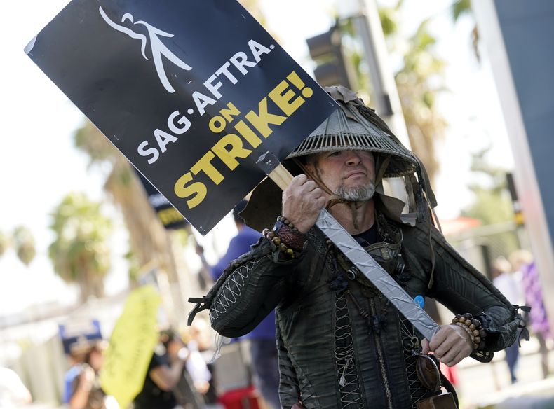 Bruce D. Mitchell, miembro del Sindicato de Actores de la Pantalla-Federación Estadounidense de Artistas de Televisión y Radio (SAG-AFTRA por sus siglas en inglés) participa en una huelga con tema post apocalíptico, fuera de los estudios de Netflix, el 8 de noviembre de 2023, en Los Ángeles. (AP Foto/Chris Pizzello, Archivo)