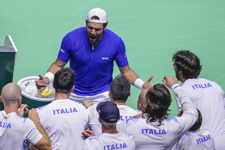 Matteo Berrettini de Italia celebra con su equipo tras vencer al australiano Thanasi Kokkinakis en la semifinal de la Copa Davis en Málaga el sabado 23 de noviembre del 2024. (AP Foto/Manu Fernandez)