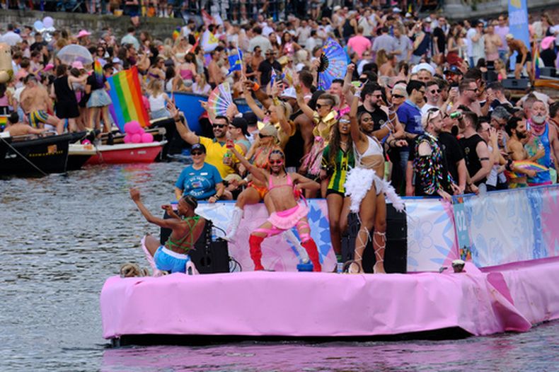 Un grupo de personas celebra a bordo de una embarcación en uno de los canales históricos de la capital holandesa, el sábado 1 de agosto de 2026, durante el Desfile de los Canales, el evento más popular del festival Orgullo Ámsterdam. (Foto AP/Patrick Post)