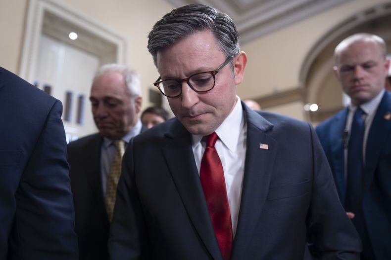 El presidente de la Cámara de Representantes, Mike Johnson, republicano por Luisiana, camina tras su equipo de seguridad a través de una multitud de periodistas mientras intenta impulsar la iniciativa de ley del presidente Donald Trump de recortes de gastos y bajadas de impuestos, pese a los reparos de congresistas republicanos conservadores y moderados, en el Capitolio en Washington, el miércoles 2 de julio de 2025. (AP Foto/J. Scott Applewhite)