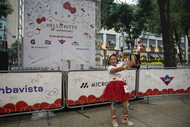 Una fan del personaje japonés Hello Kitty se toma una selfie antes de competir en una carrera, durante la celebración del 50 aniversario del personaje, en la Ciudad de México, el domingo 13 de octubre de 2024. (Foto AP/Aurea Del Rosario)