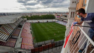 Un hombre en un balcón observa el partido de la segunda división entre el Rayo Vallecano y el Albacete en Madrid, España, el 10 de junio de 2020. (Foto AP/Manu Fernández, Archivo)