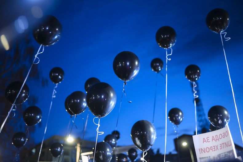 Varias personas portan globos durante una manifestación en la ciudad de Kocani, en Macedonia del Norte, el 18 de marzo de 2025, tras un incendio en un local de ocio nocturno dos días antes. (AP Foto/Armin Durgut)