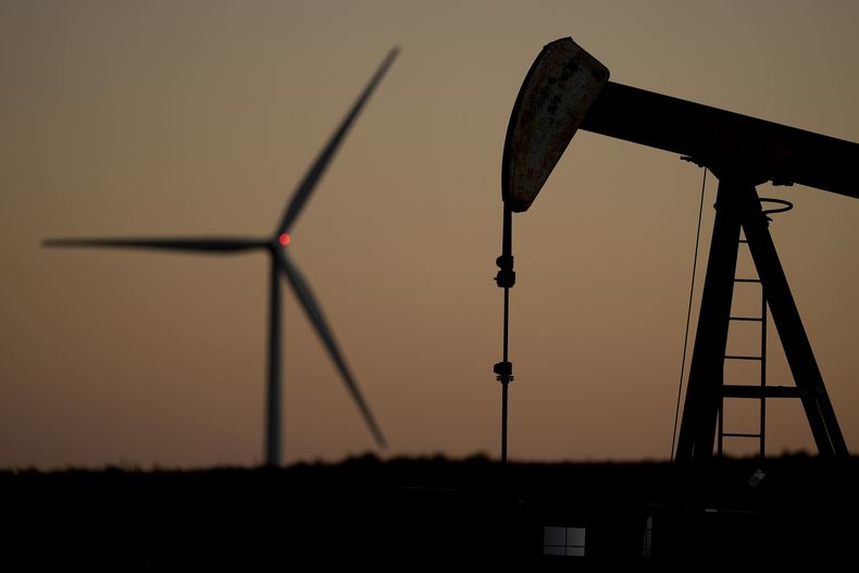Un extractor de petróleo y un molino de energía eólica cerca de Hays, Kansas, el 30 de septiembre del 2024. (AP foto/Charlie Riedel)