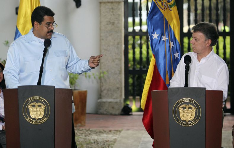 El presidente venezolano Nicol&aacute;s Maduro, a la izquierda, hace un gesto mientras dialoga con su hom&oacute;logo colombiano Juan Manuel Santos, derecha, durante una conferencia de prensa despu&eacute;s de una reuni&oacute;n bilateral en Cartagena, Co
