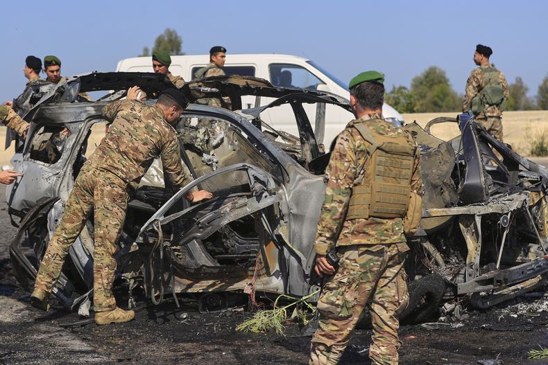 Soldados del Ejército libanés inspeccionan un automóvil calcinado que fue alcanzado por un ataque israelí, en la ciudad costera sureña de Ghazieh, Líbano, el viernes 18 de abril de 2025. (AP Foto/Mohammed Zaatari)