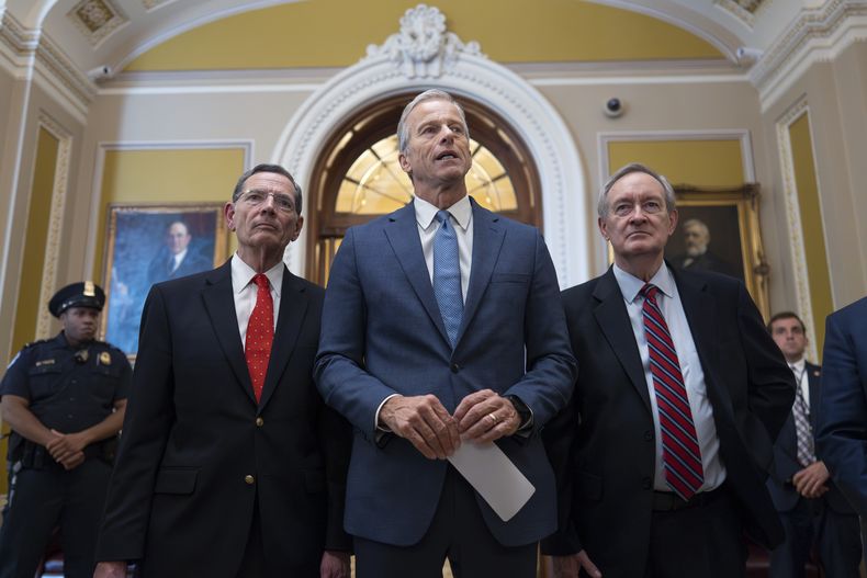 El líder de la mayoría del Senado de Estados Unidos, John Thune, acompañado por el senador John Barrasso, jefe de la bancada republicana, izquierda, y el presidente de la Comisión de Finanzas, Mike Crapo, habla con reporteros tras la aprobación del paquete de conciliación presupuestaria del proyecto de ley del presidente Donald Trump de grandes exenciones fiscales y recortes de gastos, en el Capitolio, Washington, el martes 1 de julio de 2025. (AP Foto/J. Scott Applewhite)