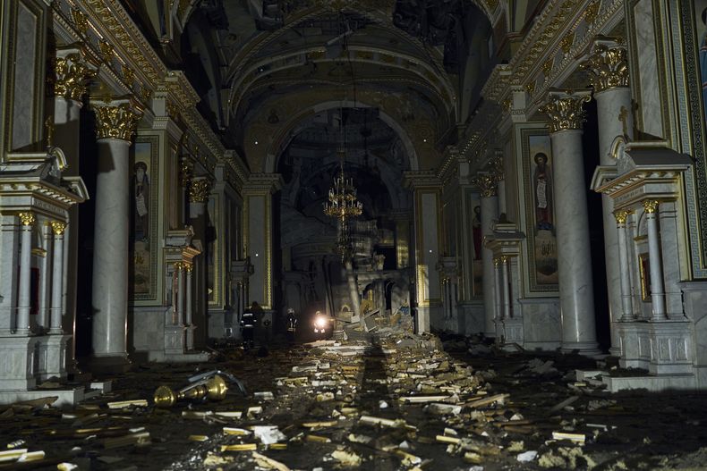 Bomberos caminan dentro de la catedral de Transfiguración de Odesa, muy dañada por un ataque de misiles en Odesa, Ucrania, el domingo 23 de julio de 2023. (AP Foto/Libkos)