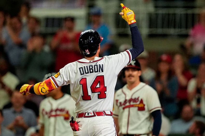 Mauricio Dubón, de los Bravos, celebra su cuadrangular de dos carreras en el juego de béisbol de Grandes Ligas contra los Cachorros de Chicago, en la octava entrada, el miércoles 13 de mayo de 2026, en Atlanta. (AP Foto/Mike Stewart)