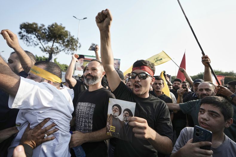 Simpatizantes de Hezbollah corean consignas en una reunión para dar la bienvenida a Ali Larijani, líder del Consejo de Seguridad de Irán, fuera del Aeropuerto Internacional Rafik Hariri en Beirut, Líbano, el miércoles 13 de agosto de 2025. (AP Foto/Bilal Hussein)