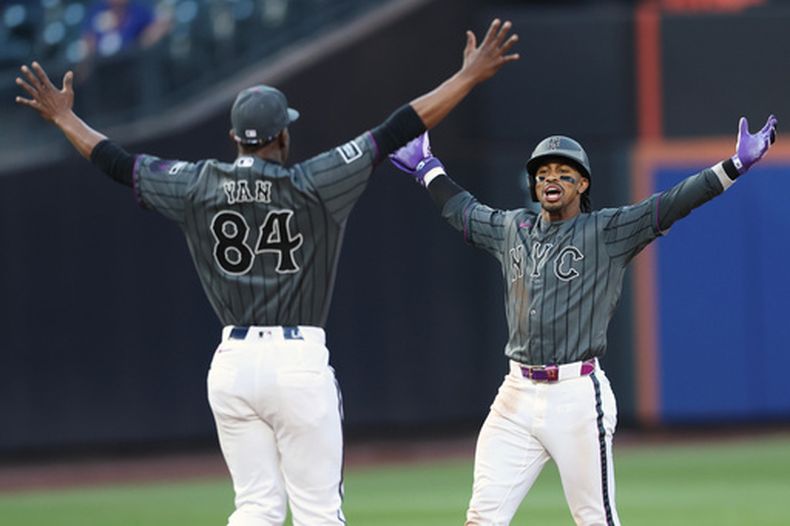 Francisco Lindor, de los Mets de Nueva York, celebra con el pitcher Jefry Yan (84) el sencillo ganador durante la novena entrada del juego de béisbol frente a los Nacionales de Washignton, el sábado 15 de agosto de 2026, en Nueva York. (AP Foto/ Heather Khalifa)