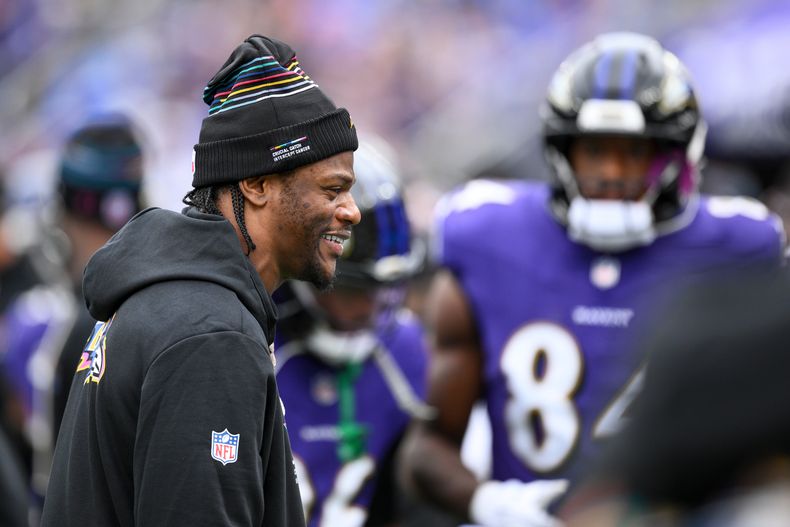 Lamar Jackson, quarterback de los Ravens de Baltimore, camina en la banca y platica con sus compañeros de equipo durante la primera mitad del partido de la NFL frente a los Rams de Los Ángeles, el domingo 12 de octubre de 2025, en Baltimore. (AP Foto/Nick Wass)