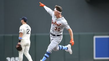 Kerry Carpenter de los Tigres de Detroit apunta hacia donde pegó su jonrón mientras recorre las bases superando al segunda base de los Mellizos de Minnesota Kyle Farmer en el encuentro del domingo 18 de junio del 2023. (AP Foto/Craig Lassig)