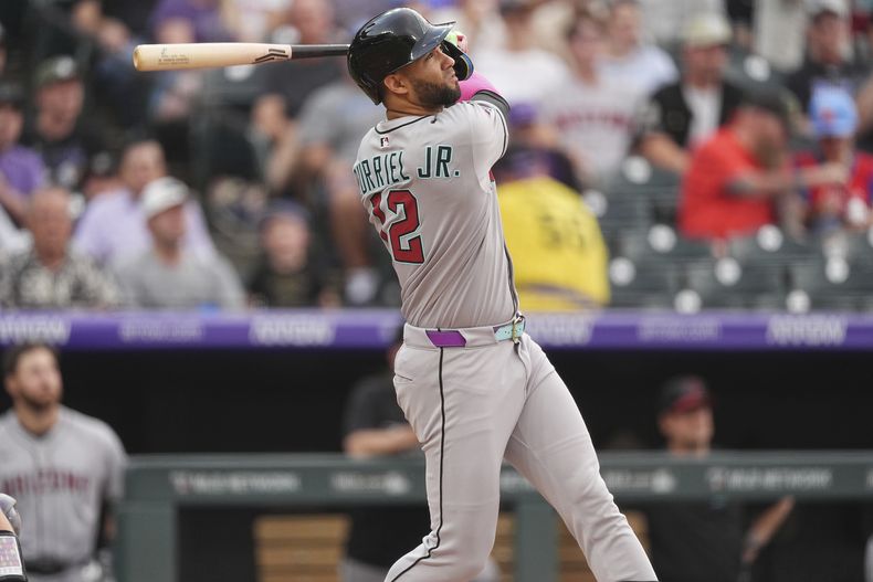 El cubano Lourdes Gurriel Jr., de los Diamondbacks de Arizona, sigue el vuelo de la pelota al conectar un jonrón de tres carreras ante los Rockies de Colorado, el jueves 14 de agosto de 2025 (AP Foto/David Zalubowski)